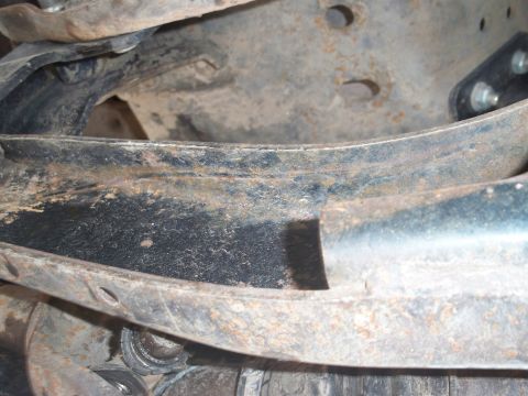 1996 Ford Bronco - Close-up of heavily rusted metal frame parts and suspension components.