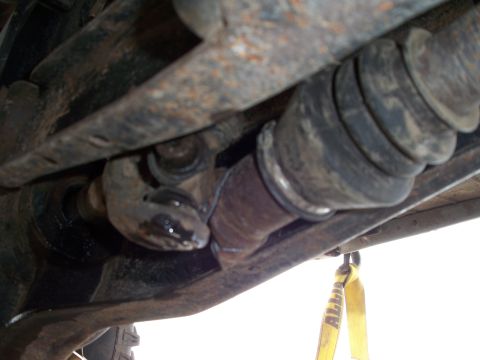 1996 Ford Bronco - Underside view of a vehicle's drivetrain components, highlighting a worn CV joint and driveshaft.