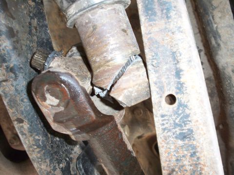 1996 Ford Bronco - A severely damaged steering linkage component shows signs of significant metal stress and failure.