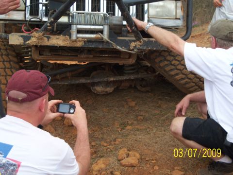 1996 Ford Bronco - A man photographs the front axle and winch of a muddy off-road vehicle on March 7, 2009.