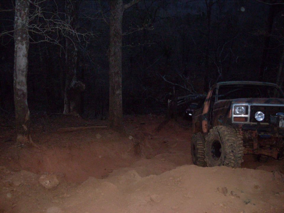 Off-road vehicle with large tires on a dirt path at night