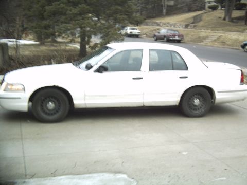 1998 Ford Crown Victoria - Side profile of a white 1998 Ford Crown Victoria sedan parked on a driveway.