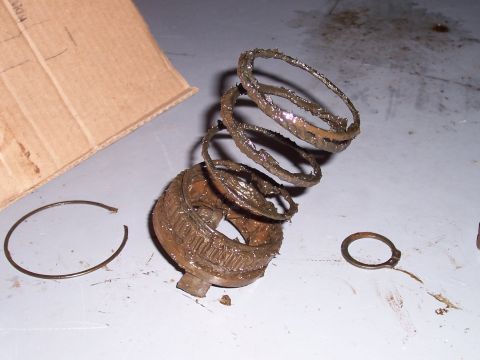 1978 Ford Bronco - Disassembled mechanical parts covered in grease are laid out on a workbench.