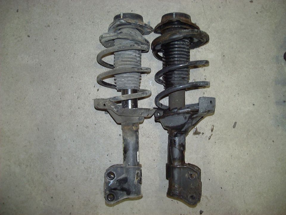 Pair of strut and coil spring assemblies on a concrete floor