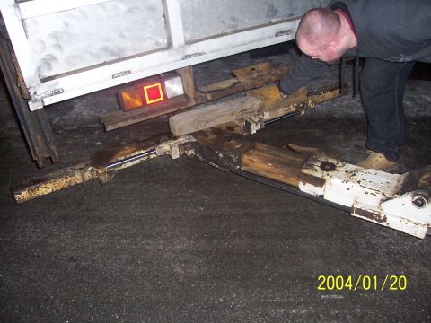 1990 Ford Bronco - A man examines a trailer hitch mechanism, showing its rusty and worn components.