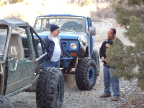 1982 Toyota 4Runner - A blue 1982 Toyota 4Runner, modified for off-roading, is parked next to a green buggy with two men standing nearby.