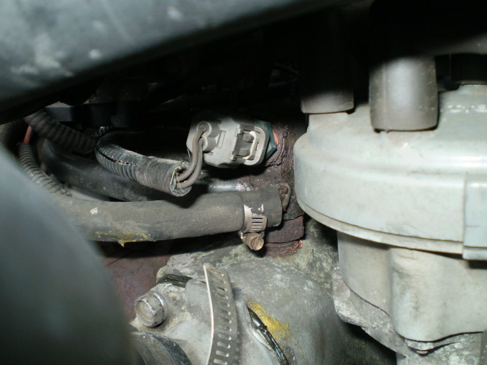 Engine components with hoses and electrical connectors, showing some corrosion and wear