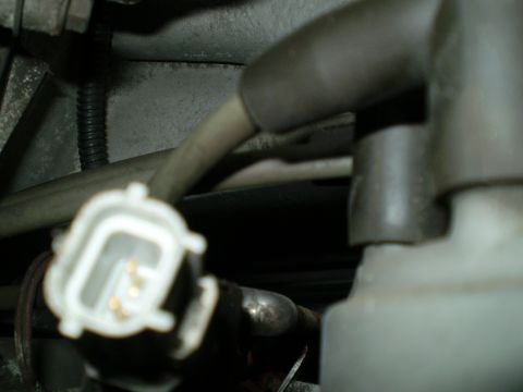 1996 Ford Bronco - A close-up view of an electrical connector with exposed gold pins, likely part of the vehicle's wiring harness.