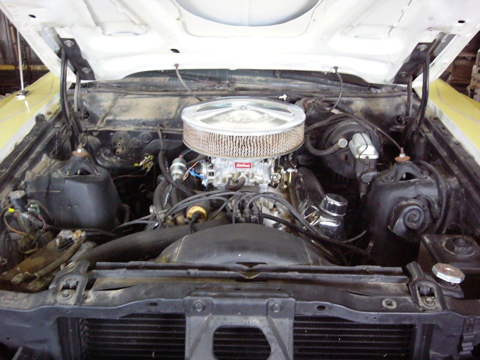 1971 Ford Ranchero engine bay with a V8 engine, chrome air cleaner, and yellow exterior visible