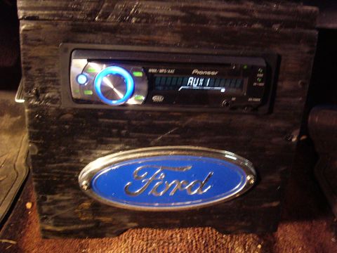 1971 Ford Ranchero - Close-up of a Ford emblem and a Pioneer car stereo mounted in a custom wooden console.