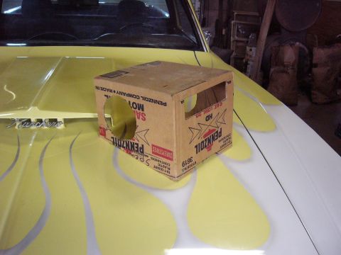 1971 Ford Ranchero - A box is placed on the hood of a car that has flame decals and 'Ranchero' badging.