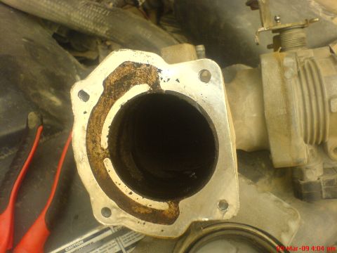 1992 Ford Crown Victoria - Close-up of a dirty throttle body and EGR channel, with red tools visible on the side.