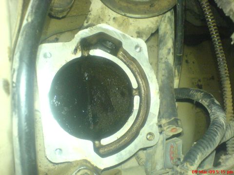 1992 Ford Crown Victoria - Close-up of a heavily carbon-fouled EGR valve, indicating a need for cleaning.