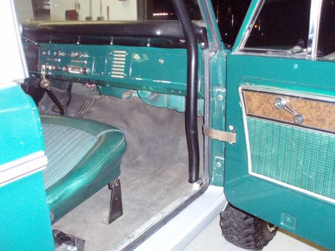 1977 Ford Bronco - The interior of a 1977 Ford Bronco is visible, including the dashboard and door panel.