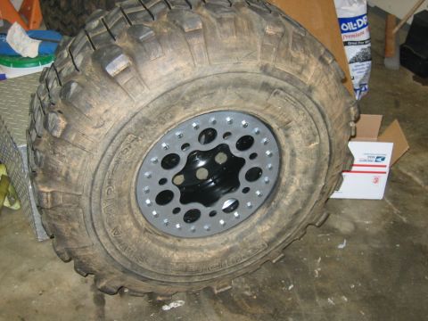 1992 Ford Mustang - Close-up of a large off-road tire mounted on a custom wheel with a unique lug nut pattern.