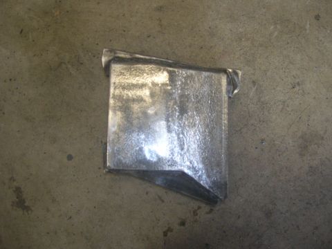 1996 Ford Bronco - A metal bracket with a bent corner is shown resting on a concrete surface.