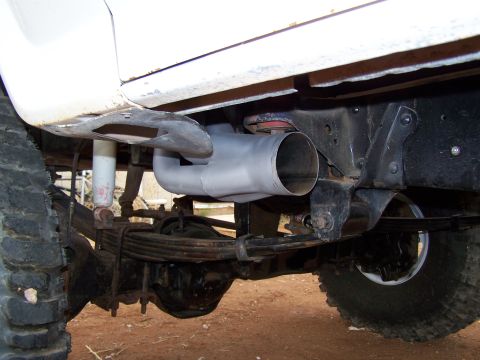 1995 Ford Bronco - Close-up view of the exhaust system and rear axle components on a truck.