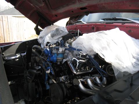 1979 Ford Bronco - Engine bay components, including chrome valve covers and headers, are covered in protective plastic.