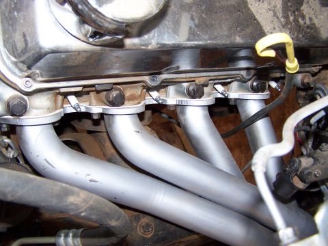 1995 Ford Bronco - Close-up view of an engine's exhaust manifold and spark plug assembly.