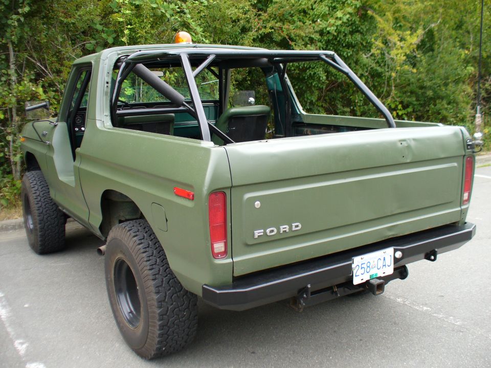 Green 1978 Ford Bronco rear view with roll cage and custom bumper