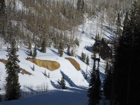 1992 Ford Bronco - An old wooden structure sits on a snowy mountainside, surrounded by trees.