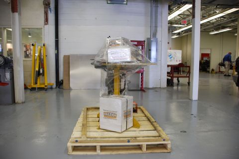 1996 Ford Bronco - A pallet holding boxes and equipment, wrapped in plastic, sits in a workshop environment.
