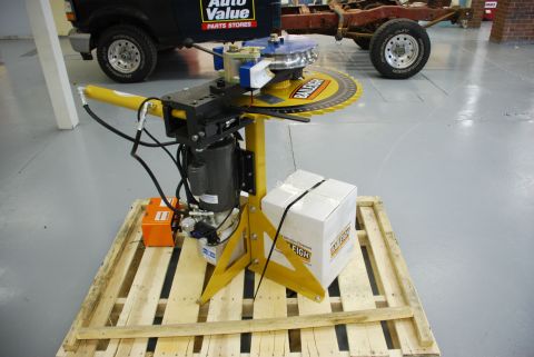 1996 Ford Bronco - A tube bender is shown in front of a Ford truck chassis and a black Ford truck.