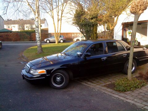 1998 Ford Crown Victoria - This black 1998 Ford Crown Victoria is parked in a driveway next to a garage.