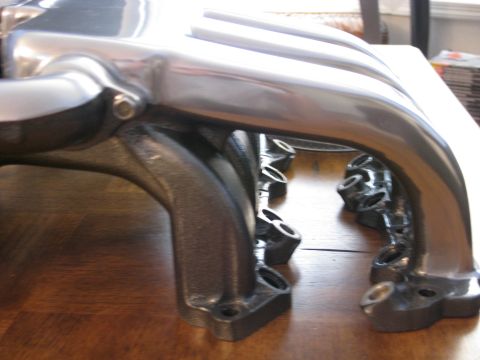 1994 Ford Probe - Close-up view of a polished intake manifold, likely a performance upgrade part, resting on a wooden table.
