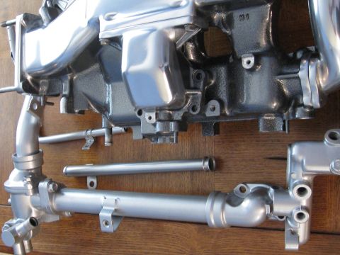 1994 Ford Probe - Engine intake manifold and plumbing components are displayed on a wooden background.