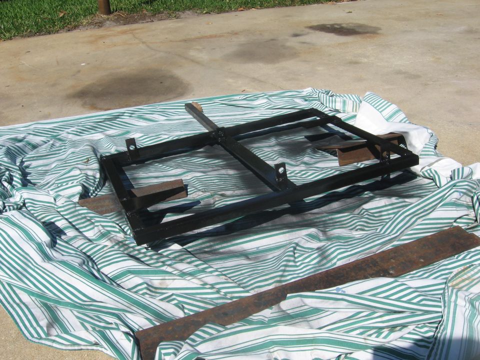 Black metal frame with wooden blocks on a green and white striped cloth