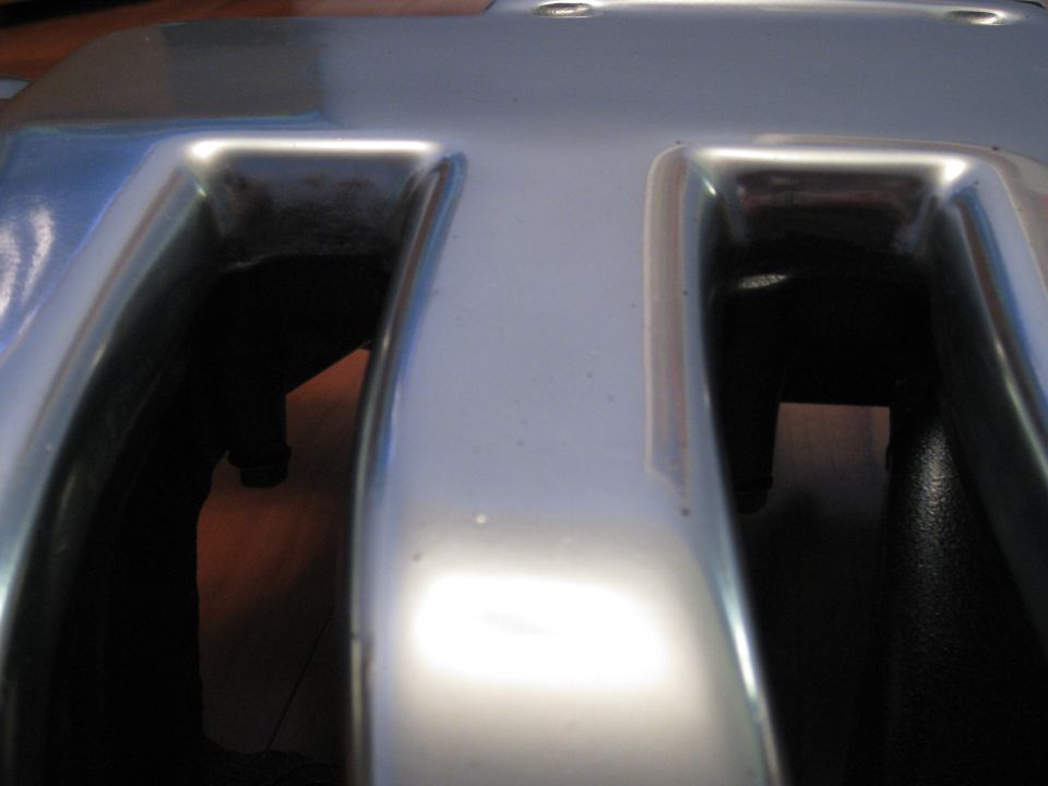 Close-up of a silver engine valve cover with two large openings
