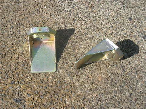 1996 Ford Bronco - Two metal suspension parts are shown on a gravel surface.