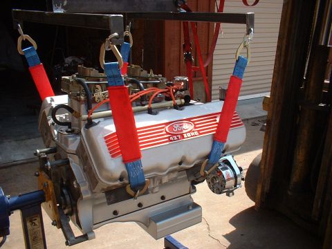 1970 Ford Mustang - A Ford 427 SOHC engine is suspended by straps, ready for installation or service.