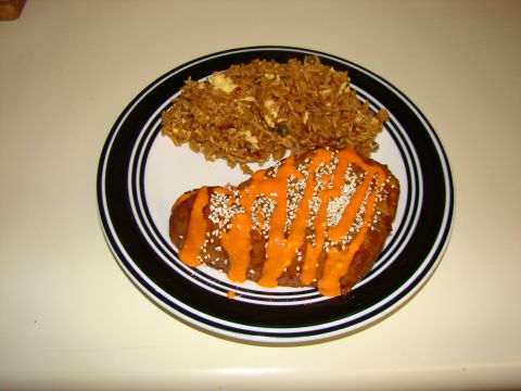 1989 Ford Bronco - A meal consisting of rice and a meat dish topped with sauce and seeds is presented on a plate.