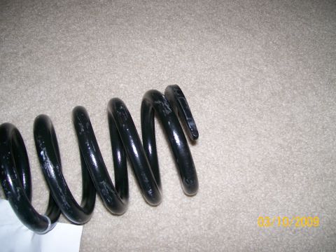 1995 Mercury Grand Marquis - A black coil spring is shown against a carpeted background.