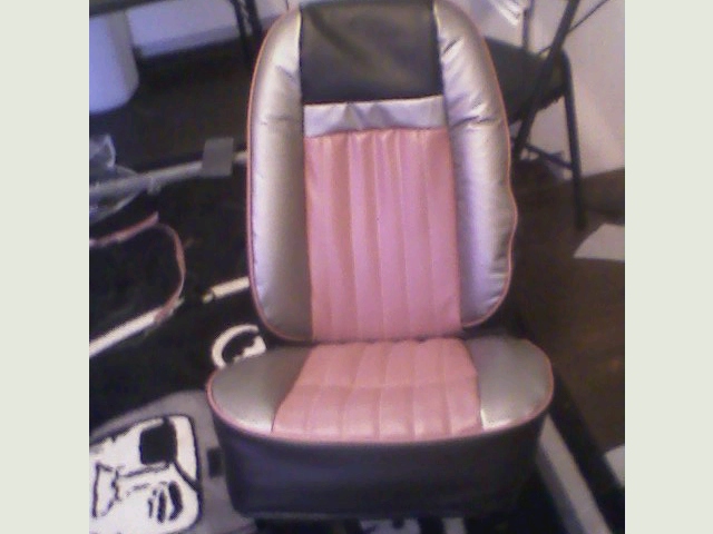 Reupholstered two-tone gray and pink vinyl bucket seat photographed indoors