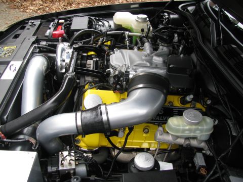 2003 Mercury Marauder - Close-up view of an engine bay, highlighting custom yellow valve covers and polished intake components.