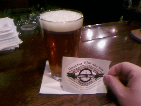 1985 Ford LTD Crown Victoria - A hand holds a sticker from Town Hall Brewery next to a glass of beer.
