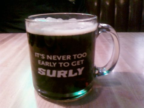 1985 Ford LTD Crown Victoria - A glass mug filled with dark beer and topped with foam, displaying the text "IT'S NEVER TOO EARLY TO GET SURLY".