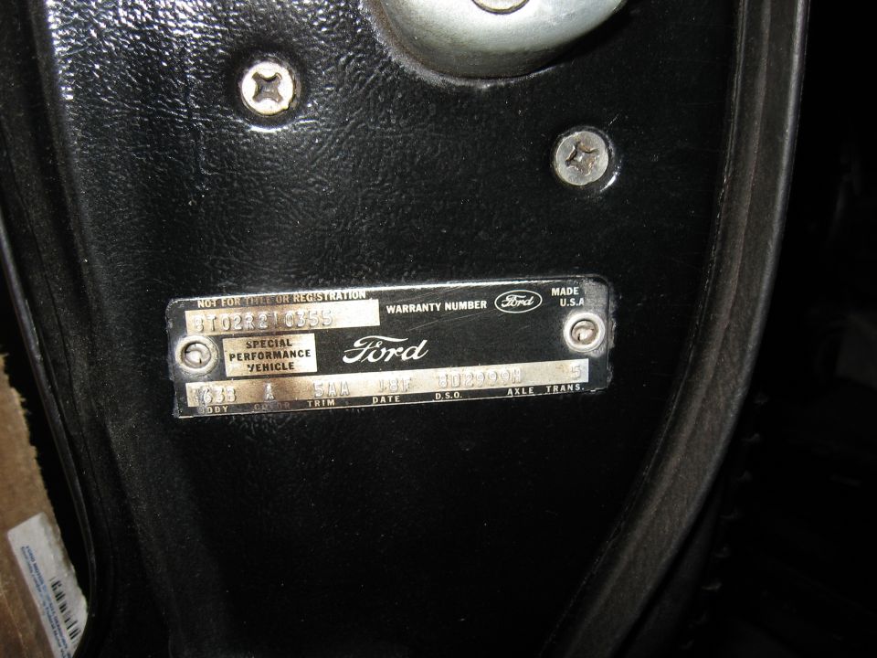 Close-up of a Ford VIN plate with warranty number and special performance vehicle designation