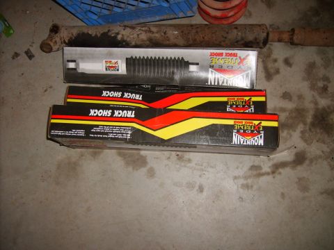 1989 Ford Bronco - Two boxes of Ryder Extreme Mountain truck shock absorbers are shown alongside a loose shock absorber and a red spring.
