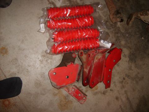 1989 Ford Bronco - Red suspension bellows and assorted metal brackets laid out on a concrete surface.