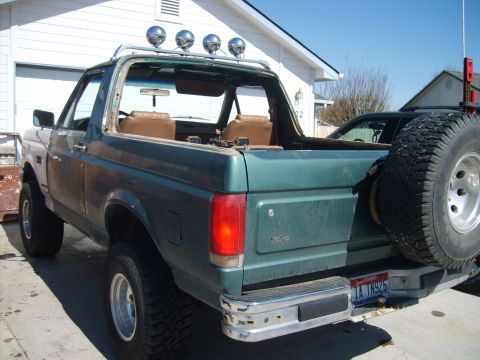 1989 Ford Bronco - This Ford Bronco has a spare tire mounted on the rear and a light bar on the roof.