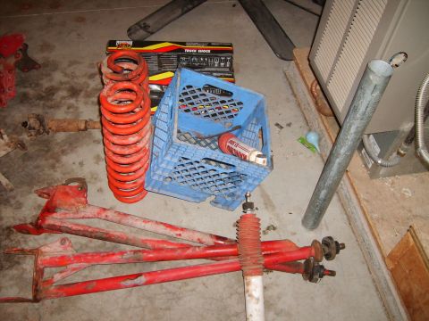 1989 Ford Bronco - Collection of vehicle suspension parts including coil springs, control arms, and shock absorbers.