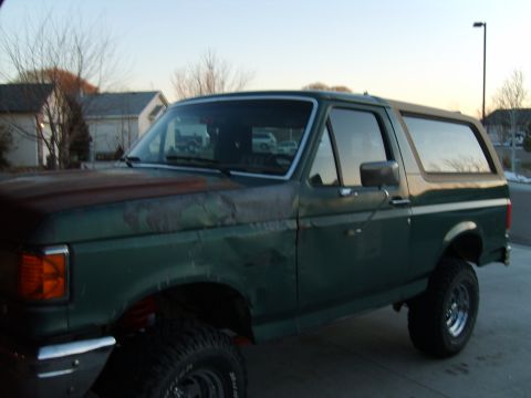 1989 Ford Bronco - This 1989 Ford Bronco is seen from a 3/4 front angle, showing its green paint and rusty hood.