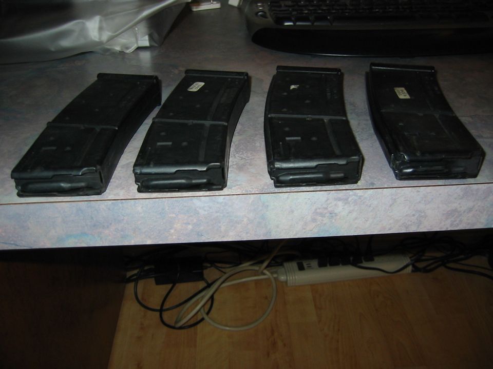 four black rifle magazines on a counter