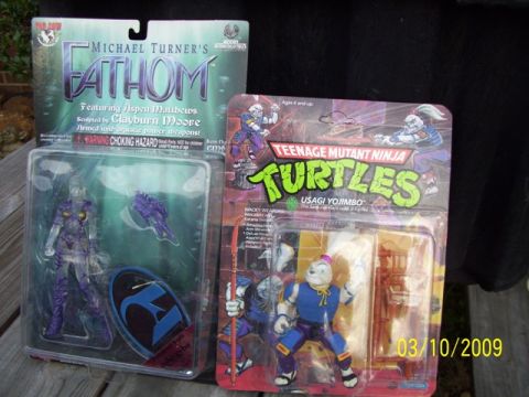 1991 Ford Bronco - Packaged Fathom and Teenage Mutant Ninja Turtle action figures are displayed on a wooden surface.