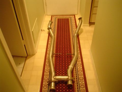 1996 Mercury Grand Marquis - A dual exhaust system is shown laid out on a rug in a hallway.