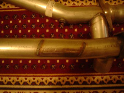 1996 Mercury Grand Marquis - Close-up view of exhaust pipes, showing welding details against a red and gold patterned rug.